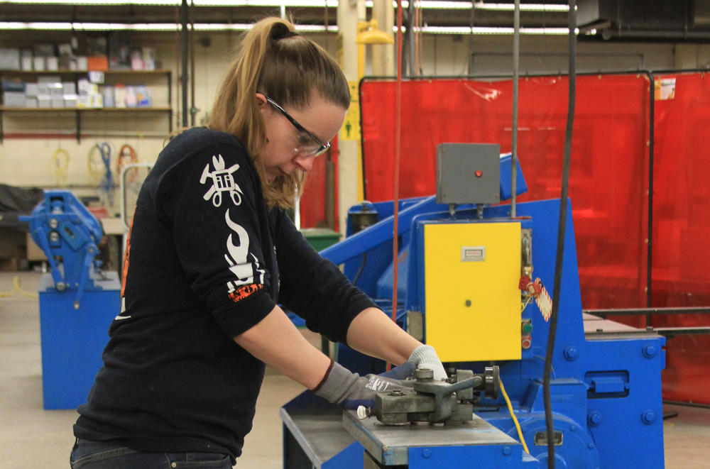 Female sheet metal apprentice bending sheet metal