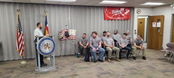 Man standing at a podium addressing a group of graduates