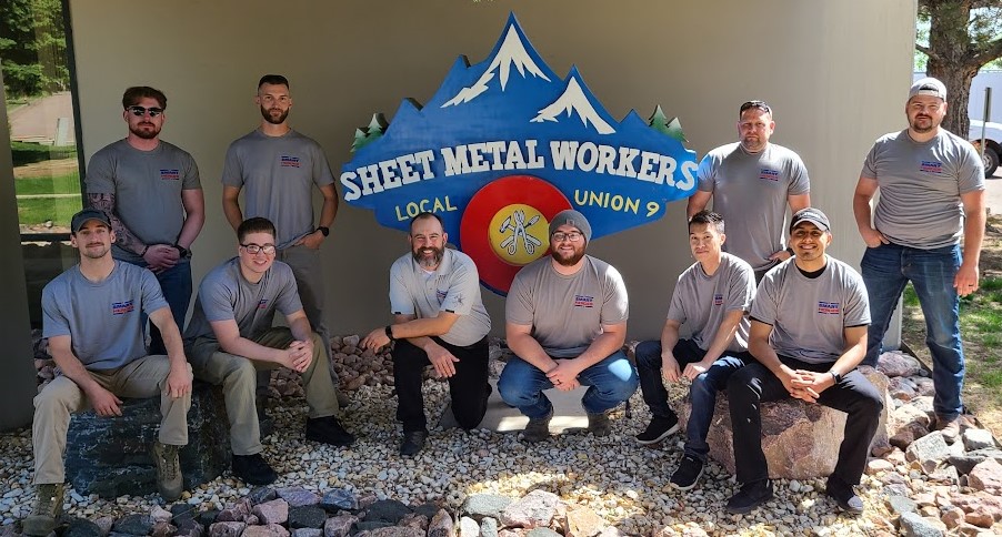 Colorado Springs SMART Heroes graduates standing in front of SMW Logo